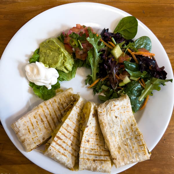 Cafe La Tazita's quesadilla with guacamole, salsa, sour cream, and a side salad.